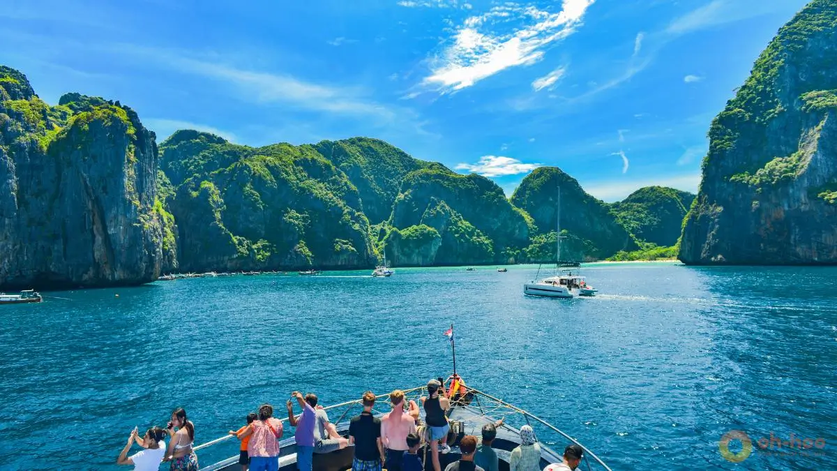 Phuket to Phi Phi Island boat tour with limestone cliffs, turquoise sea, and travelers enjoying a sunny day trip