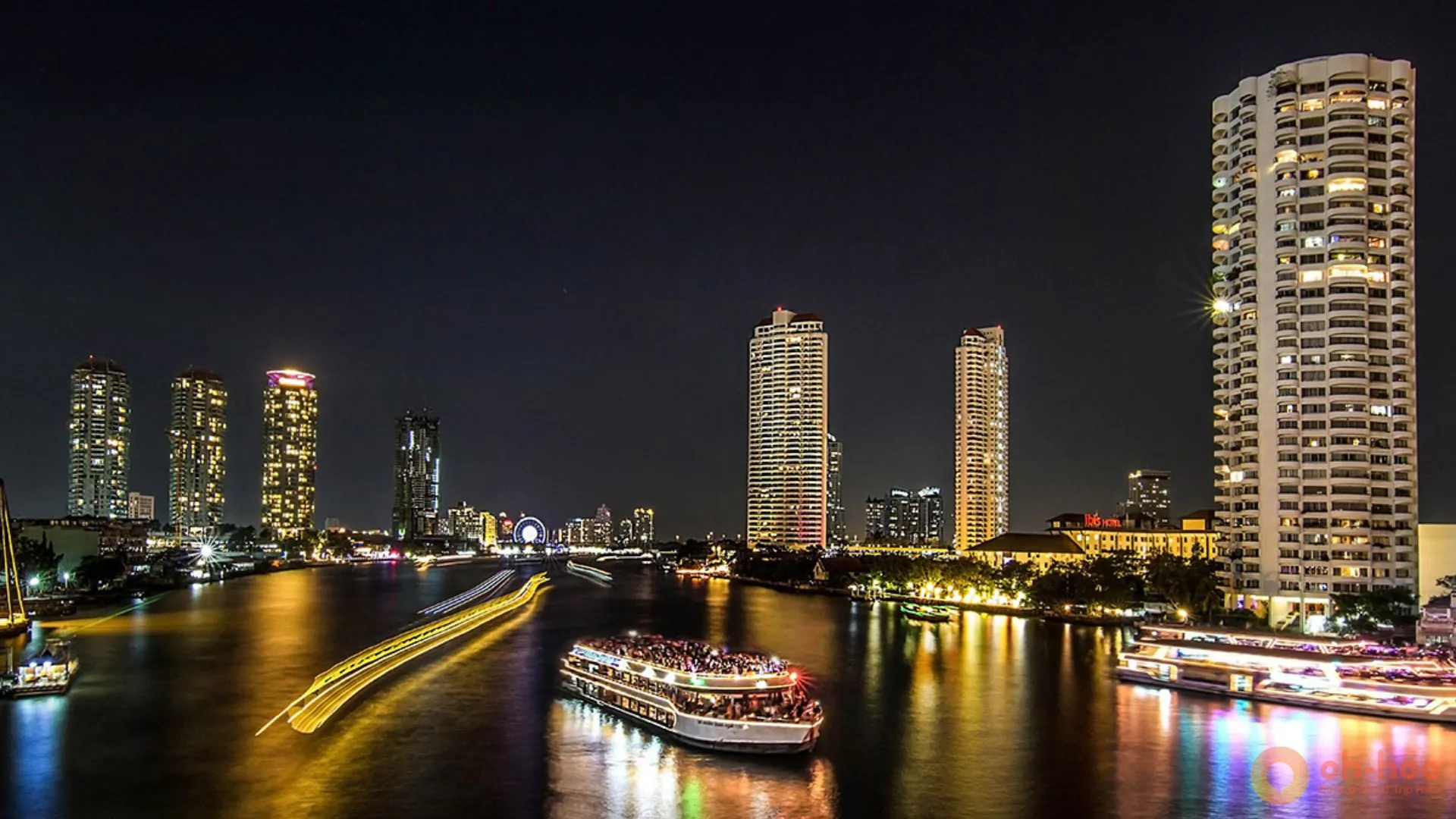 Chao Phraya River night view in Bangkok, Thailand with illuminated cruise boats and city skyline