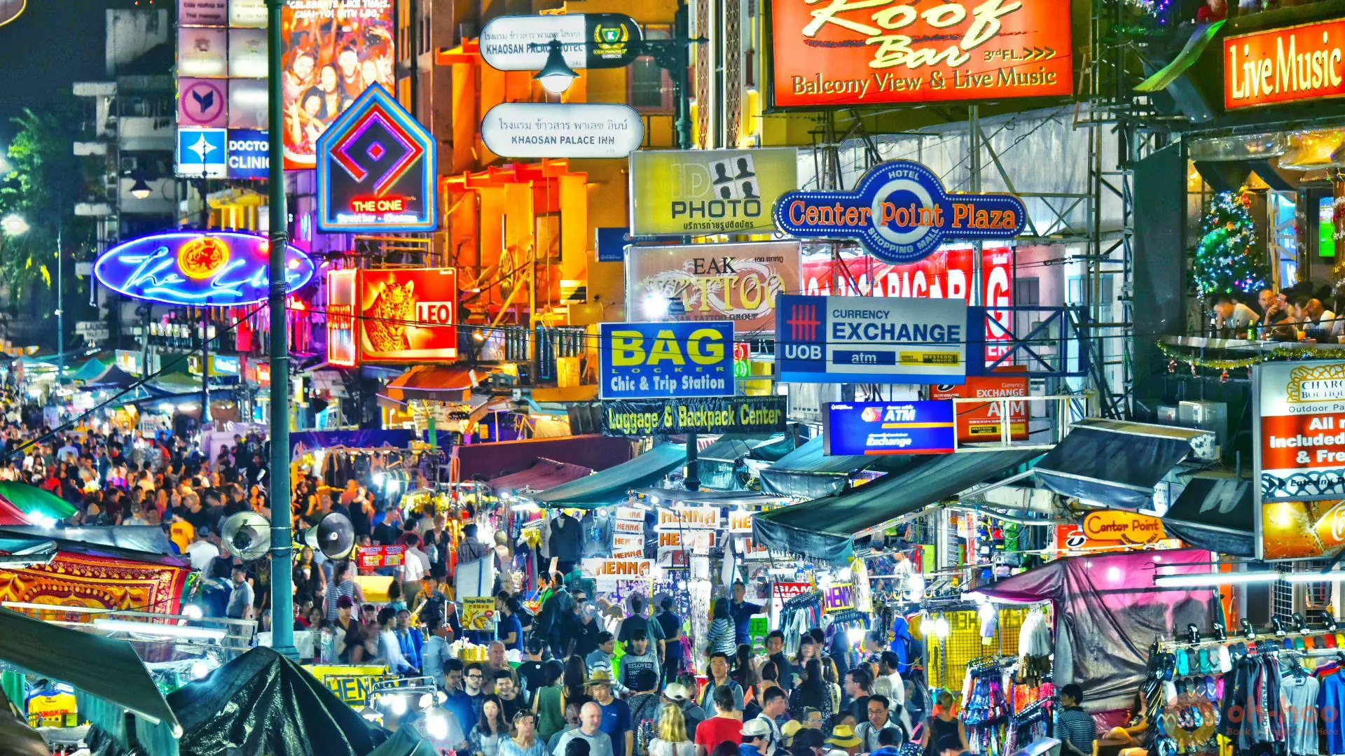 Colorful Khao San Road nightlife in Bangkok, Thailand with neon signs, street food stalls, and crowds