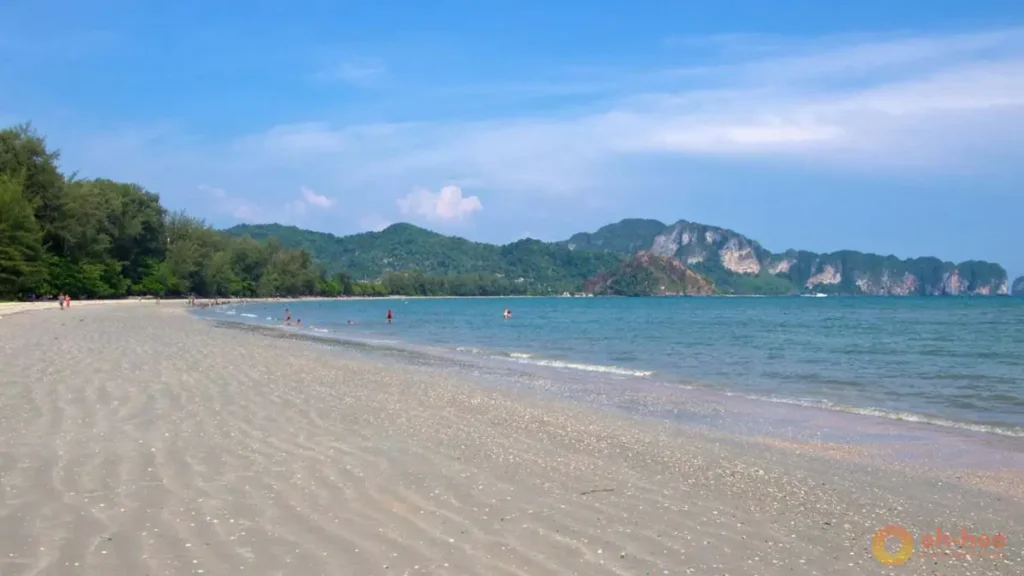 Nopparat Thara Beach in Krabi, Thailand, with a long sandy shoreline, calm sea and limestone mountain views, highlighting relaxing beach walks and coastal scenery as one of the best things to do in Krabi.