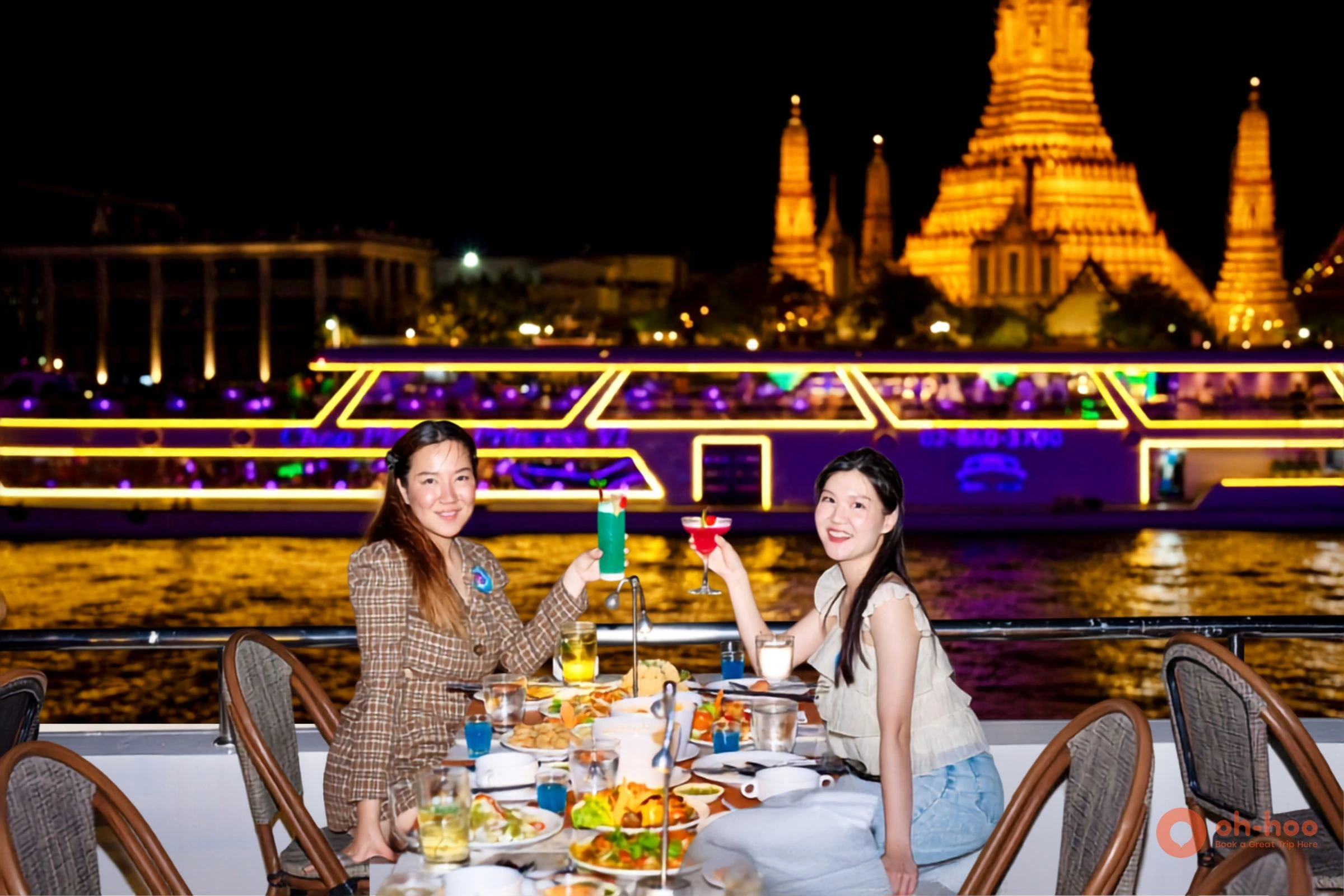 Romantic table for two with wine and city lights on a Chao Phraya dinner cruise deck