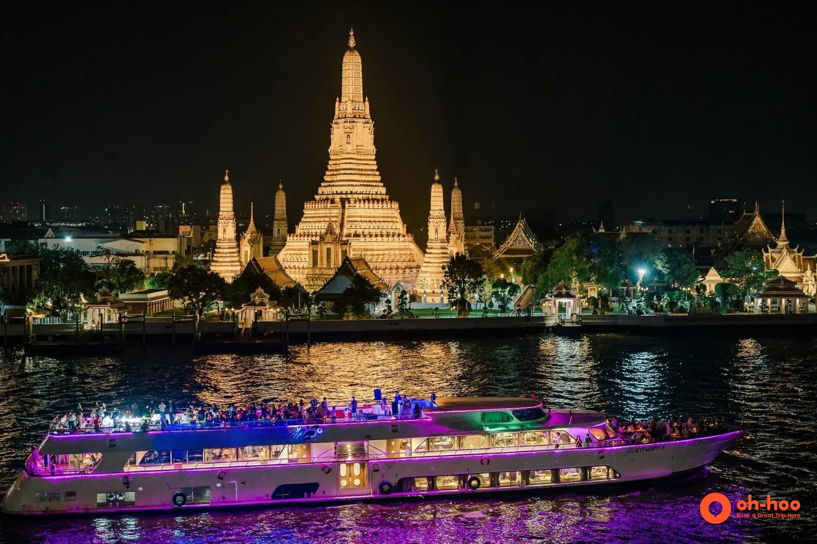 Illuminated Bangkok river cruise passing Wat Arun at night on the Chao Phraya River