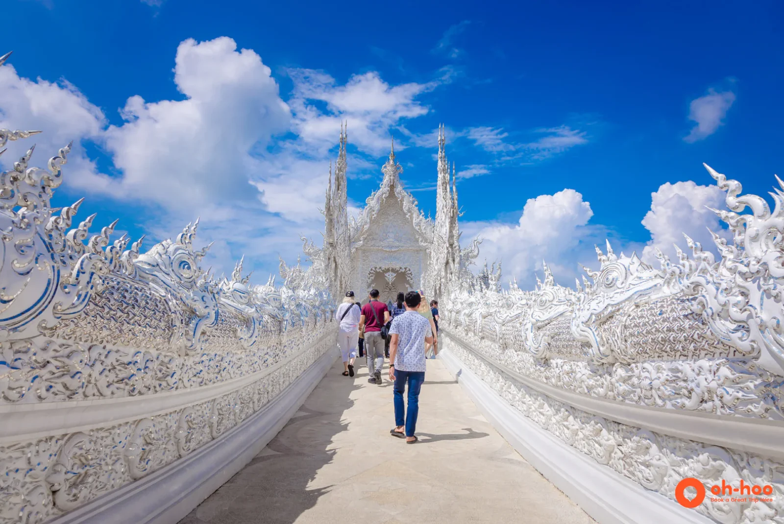 Visitors crossing the white bridge toward the hall at Wat Rong Khun in Chiang Rai
