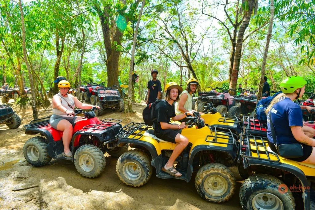Tourists in helmets on quad bikes at the start of a Phuket ATV tour through the jungle