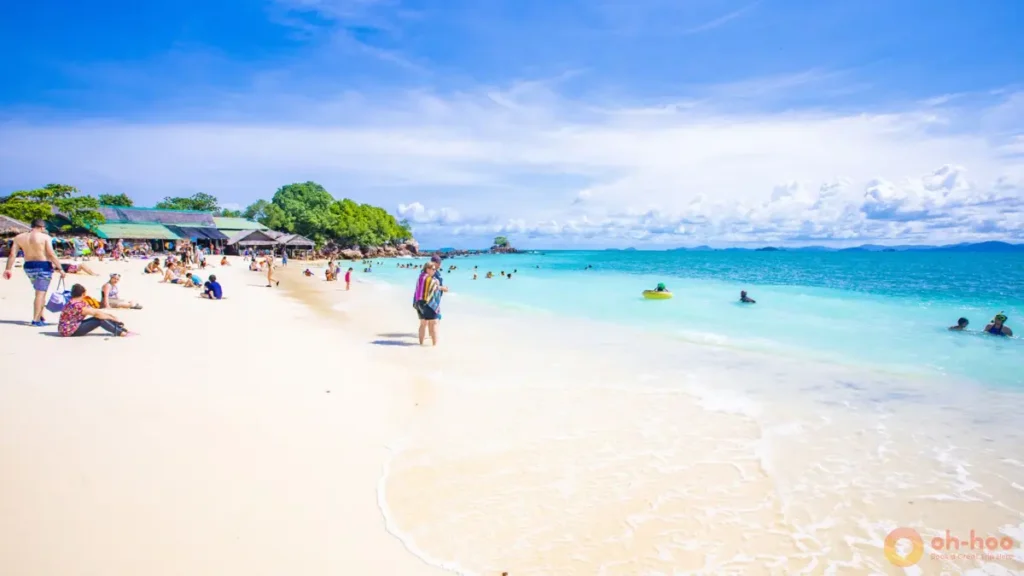 Families swimming in shallow turquoise water at Khai Island, one of the best things to do in Phuket with kids