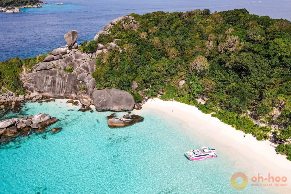 Aerial view of Sail Rock, white sand beach, and turquoise water at the Similan Islands.