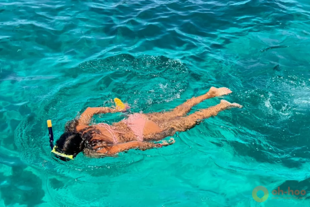 Snorkeler in turquoise shallow water at Coral Island, Phuket