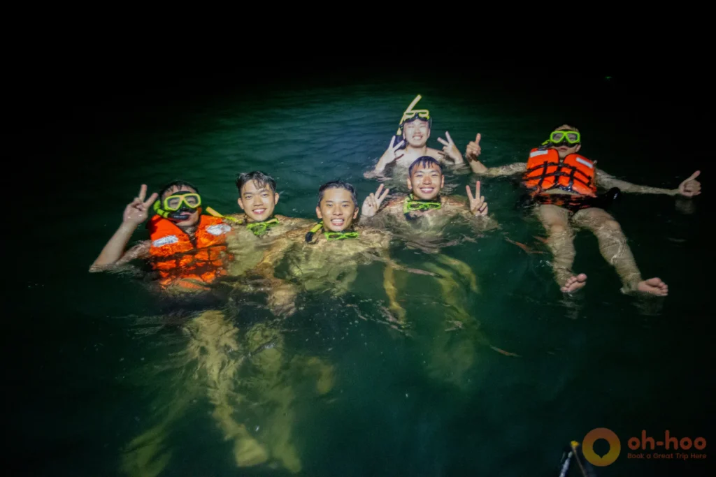 Tourists at night snorkeling to experience glowing bioluminescent plankton in Krabi
