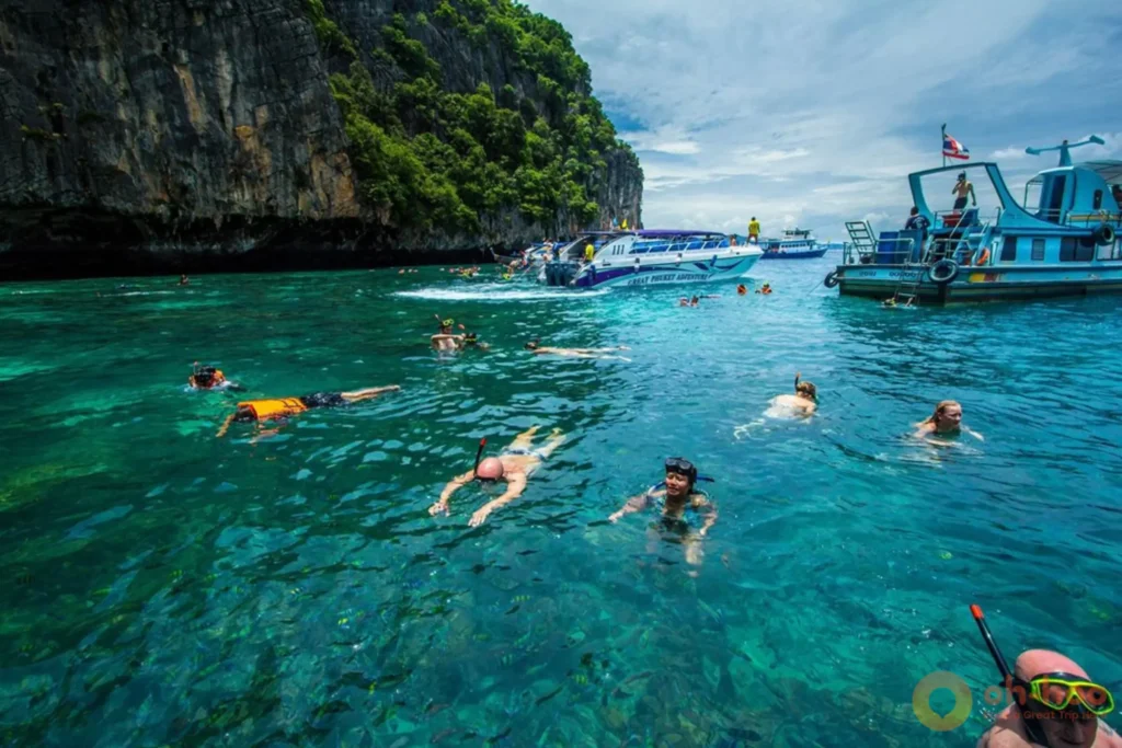 Speedboats anchored near limestone cliffs during a Phi Phi tour from Phuket