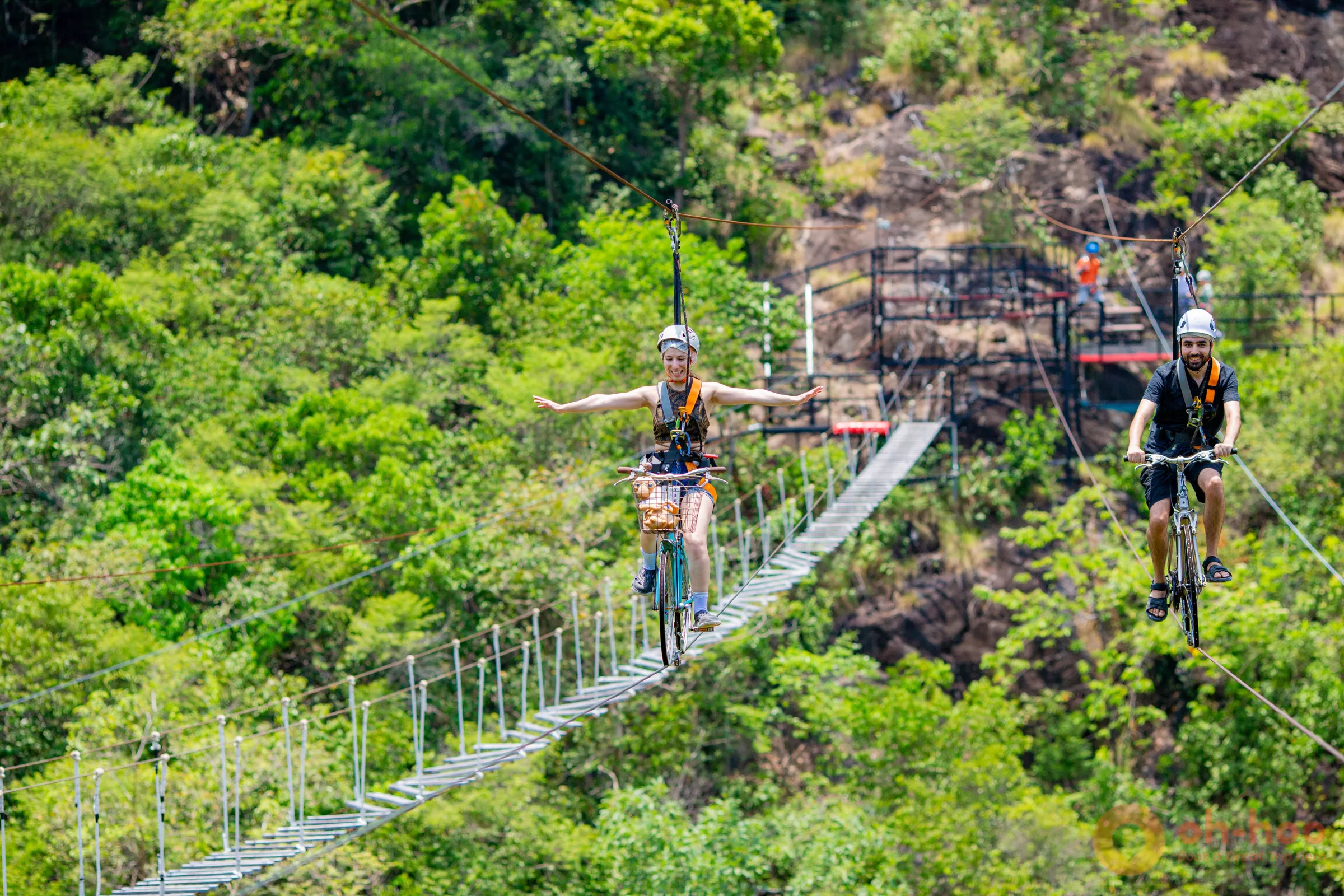 Tourist enjoying Sky Bike activity over the lush rainforest at Koh Phangan zipline park