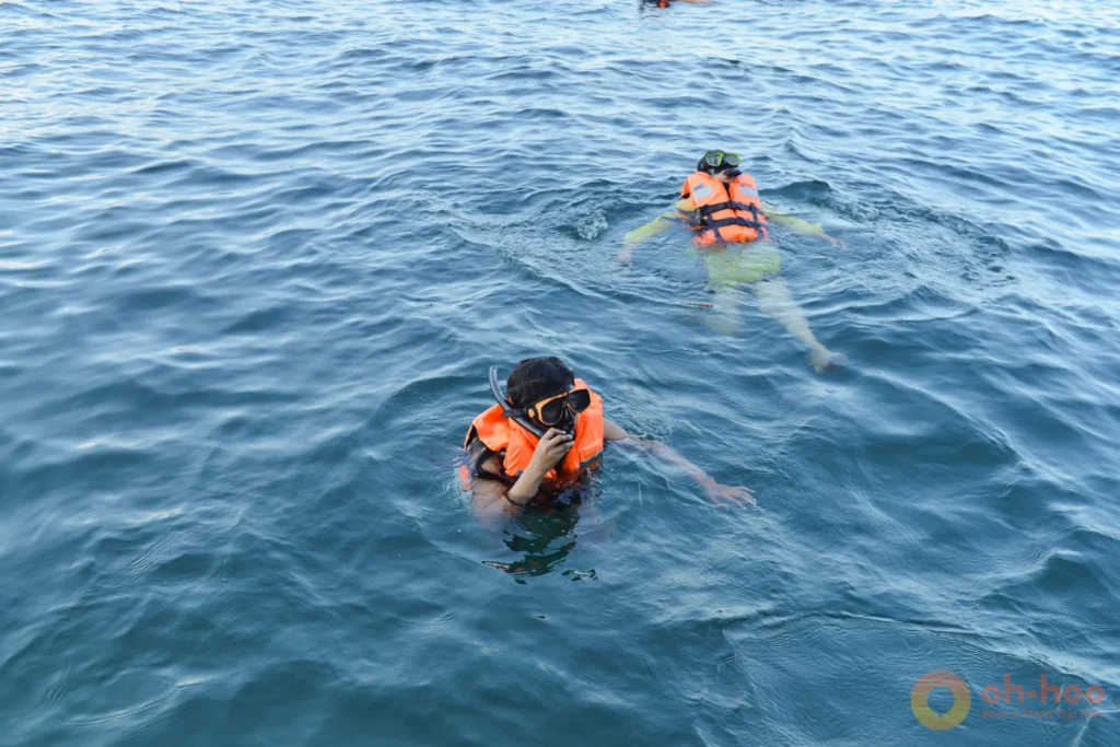 Snorkelers in orange life jackets floating in the calm sea during a Krabi 7 Islands island-hopping tour