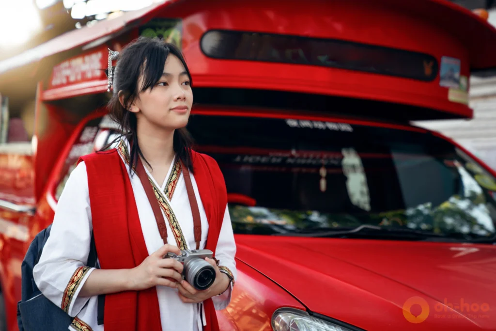 Traveler posing in front of a traditional Chiang Mai red truck songthaew