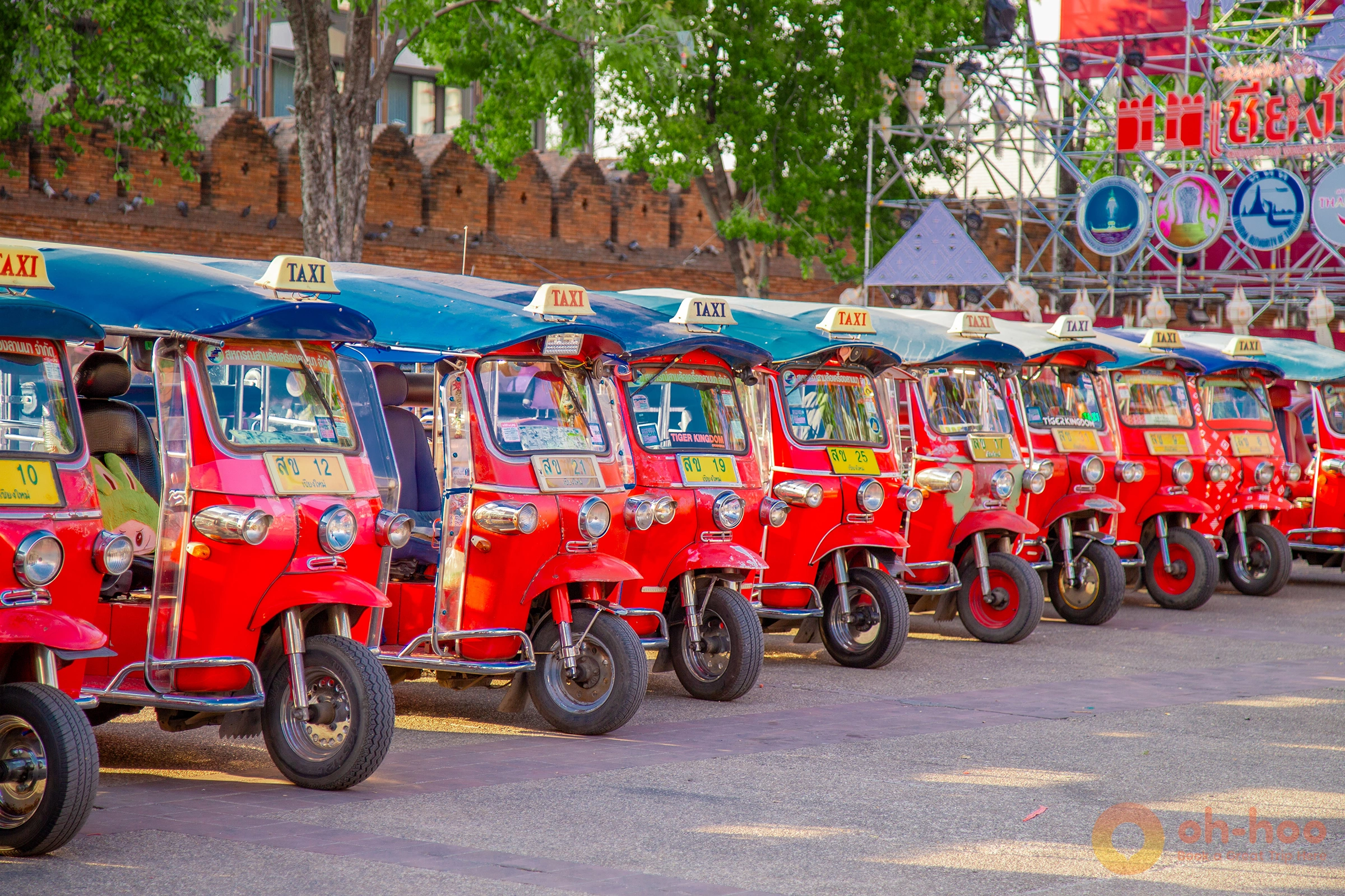 Row of iconic red tuk-tuks parked near Tha Phae Gate in Chiang Mai Old City