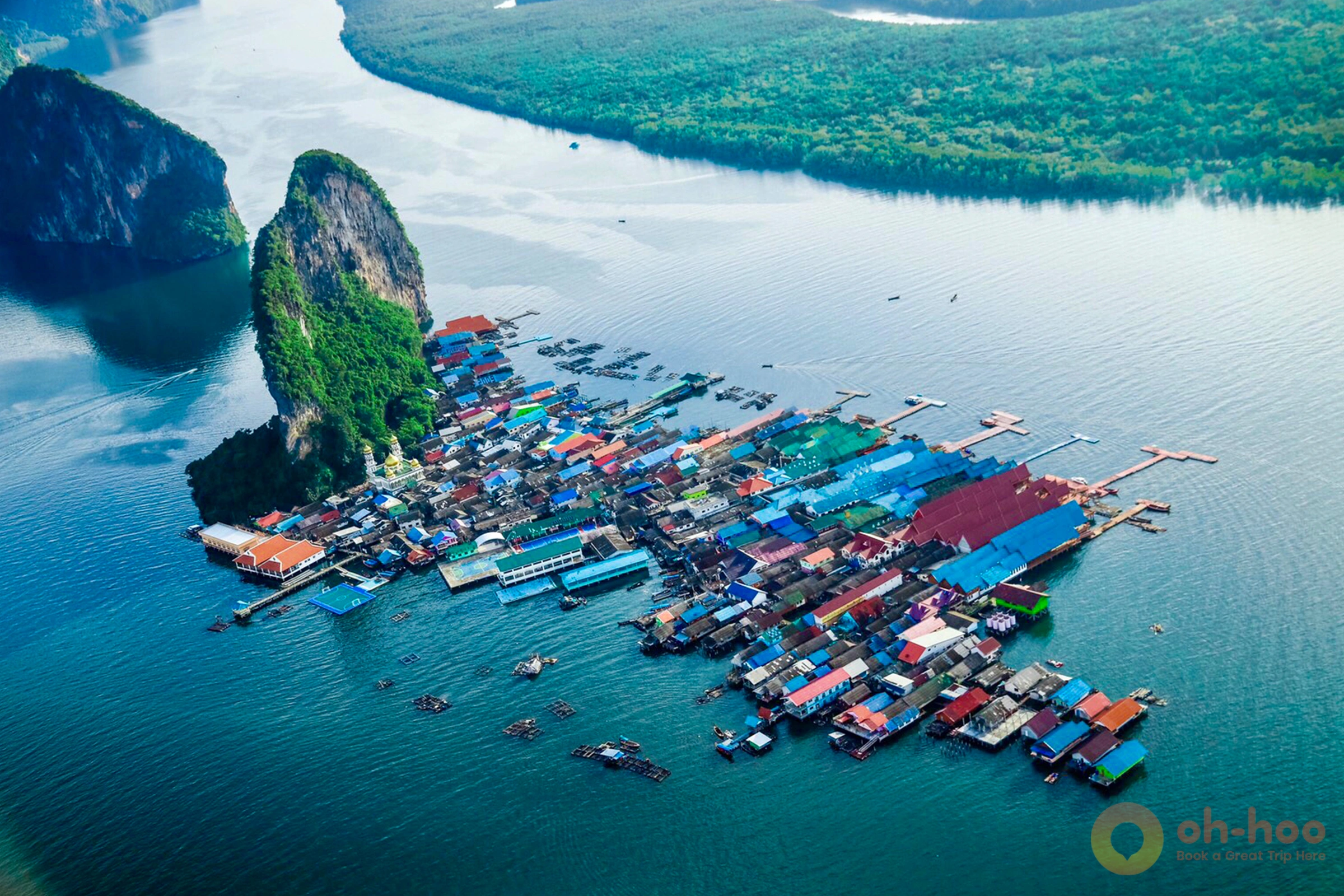 Aerial view of Koh Panyee Muslim floating village built on stilts against limestone cliff in Phang Nga Bay