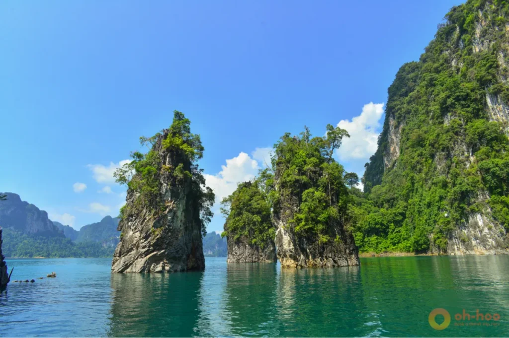 Towering limestone karsts rising above emerald waters in Khao Sok National Park, southern Thailand.