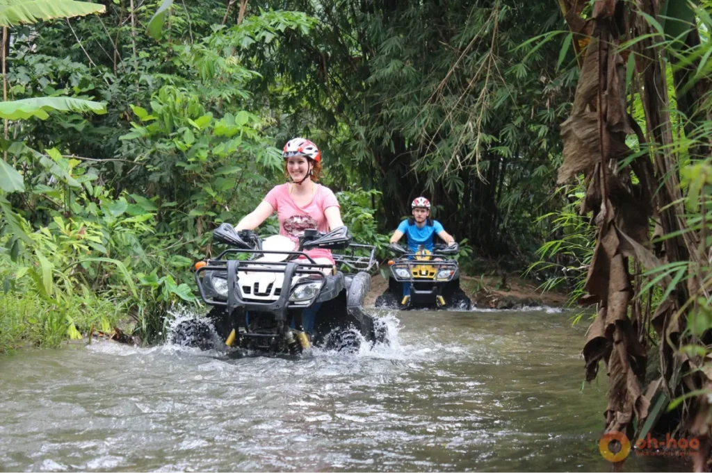 ATV riders crossing a jungle stream on an off-road adventure, one of the most exciting things to do in Khao Lak.