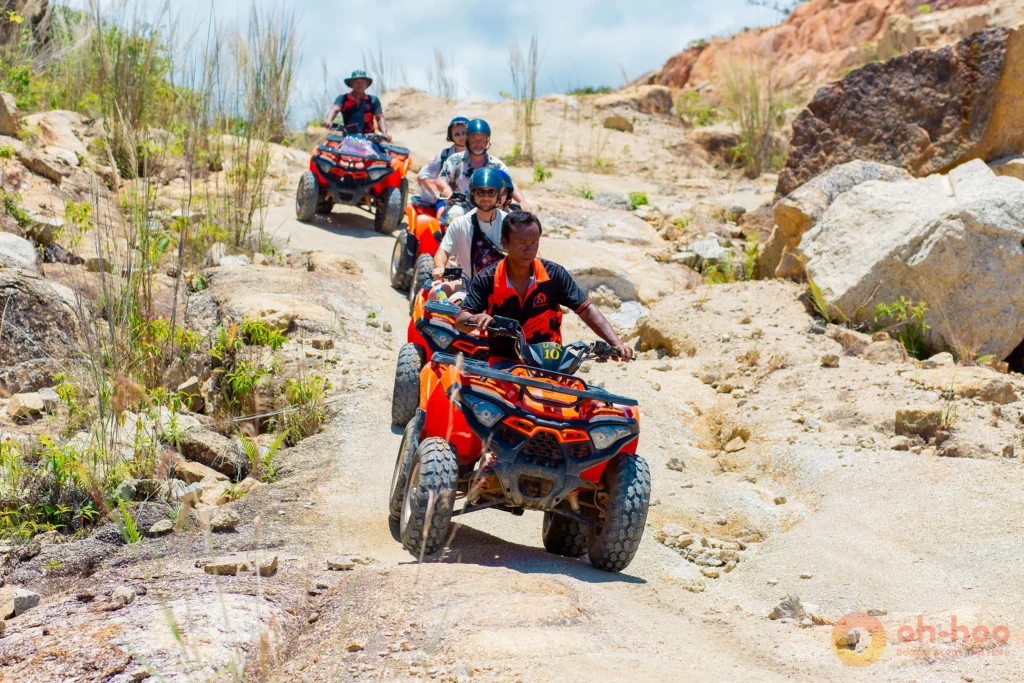 Line of ATV riders navigating a rocky off-road mountain trail in Koh Phangan.