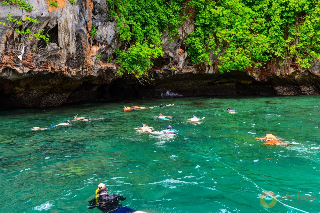 Snorkeller swimming over colourful coral and tropical fish at Koh Chuek near Koh Lanta
