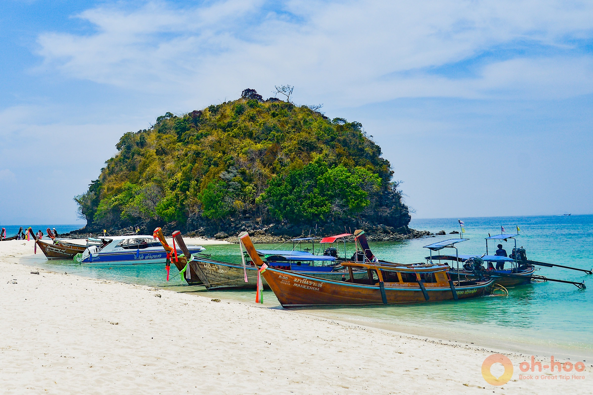 Longtail boats moored on Railay West beach at golden hour beneath towering limestone cliffs