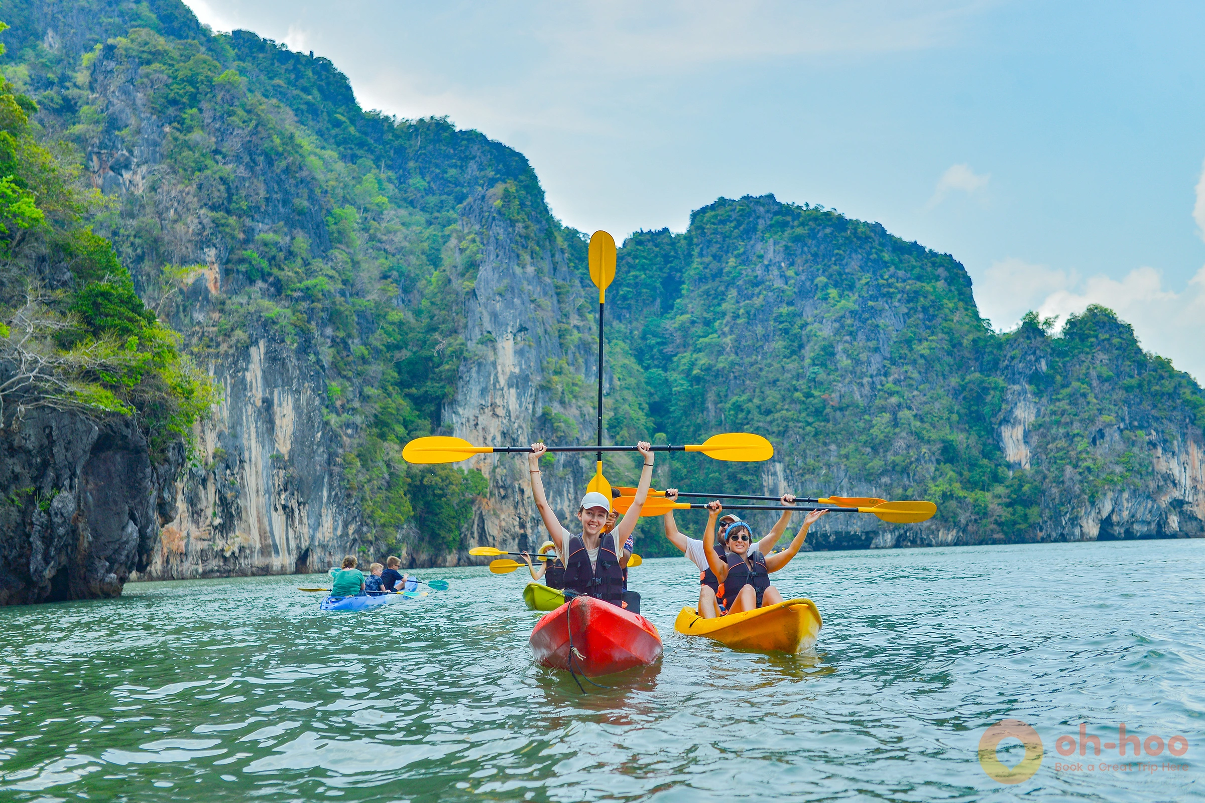 People floating above a shallow coral reef in clear turquoise water near Koh Lanta