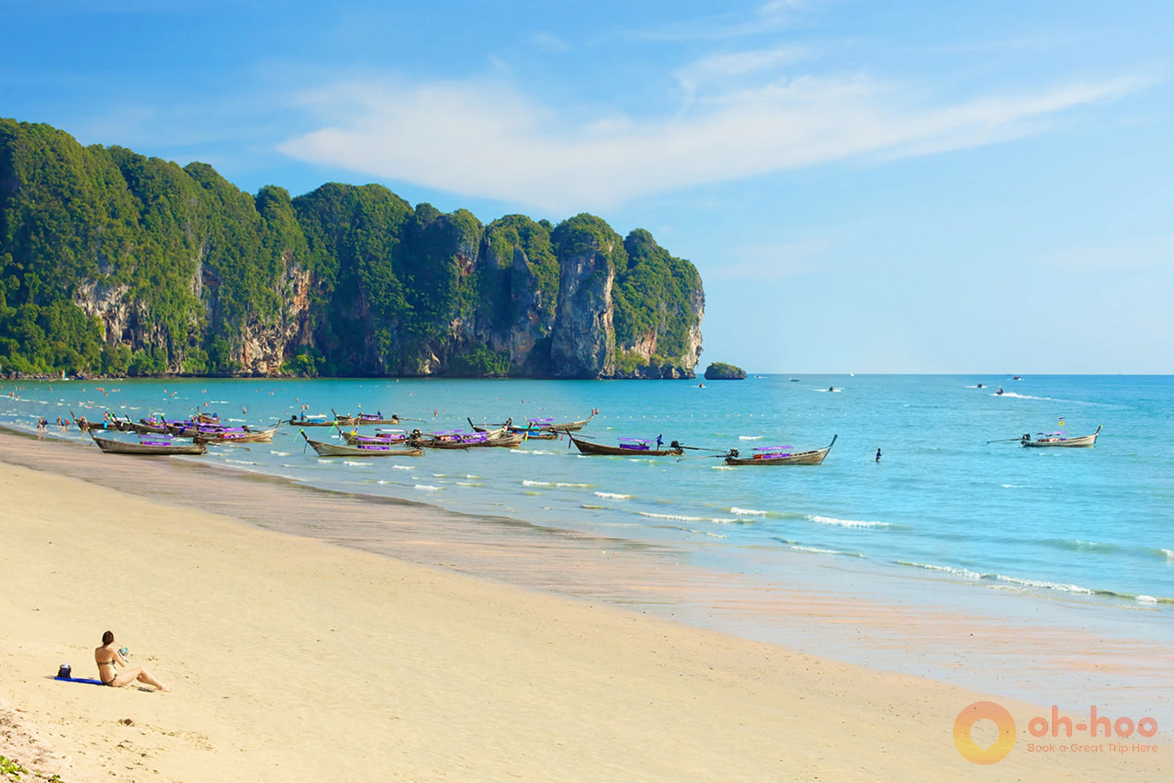Ao Nang beach with longtail boats on the sand and the beachfront strip behind