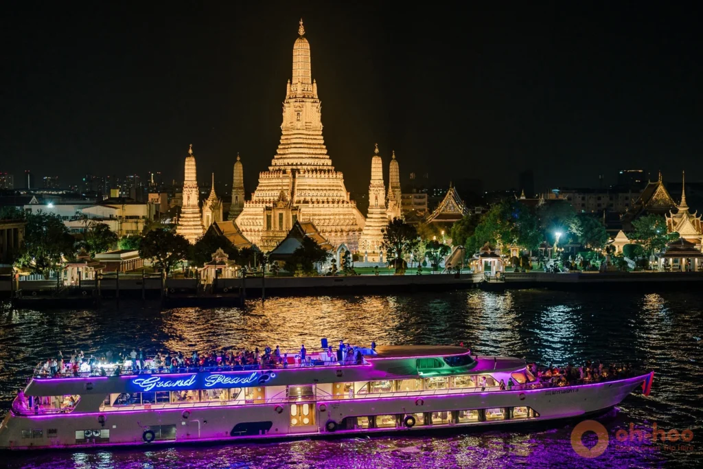 Illuminated spire of Wat Arun reflected in the Chao Phraya River at night