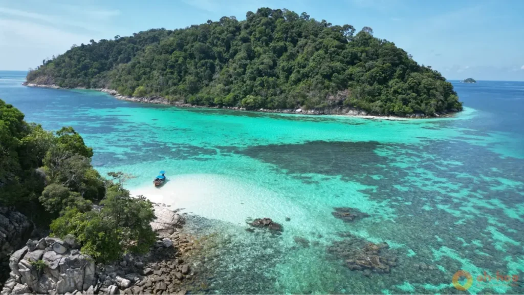 Koh Lipe snorkeling in crystal-clear turquoise water with coral reefs and a tropical island off the coast of Koh Lipe Thailand