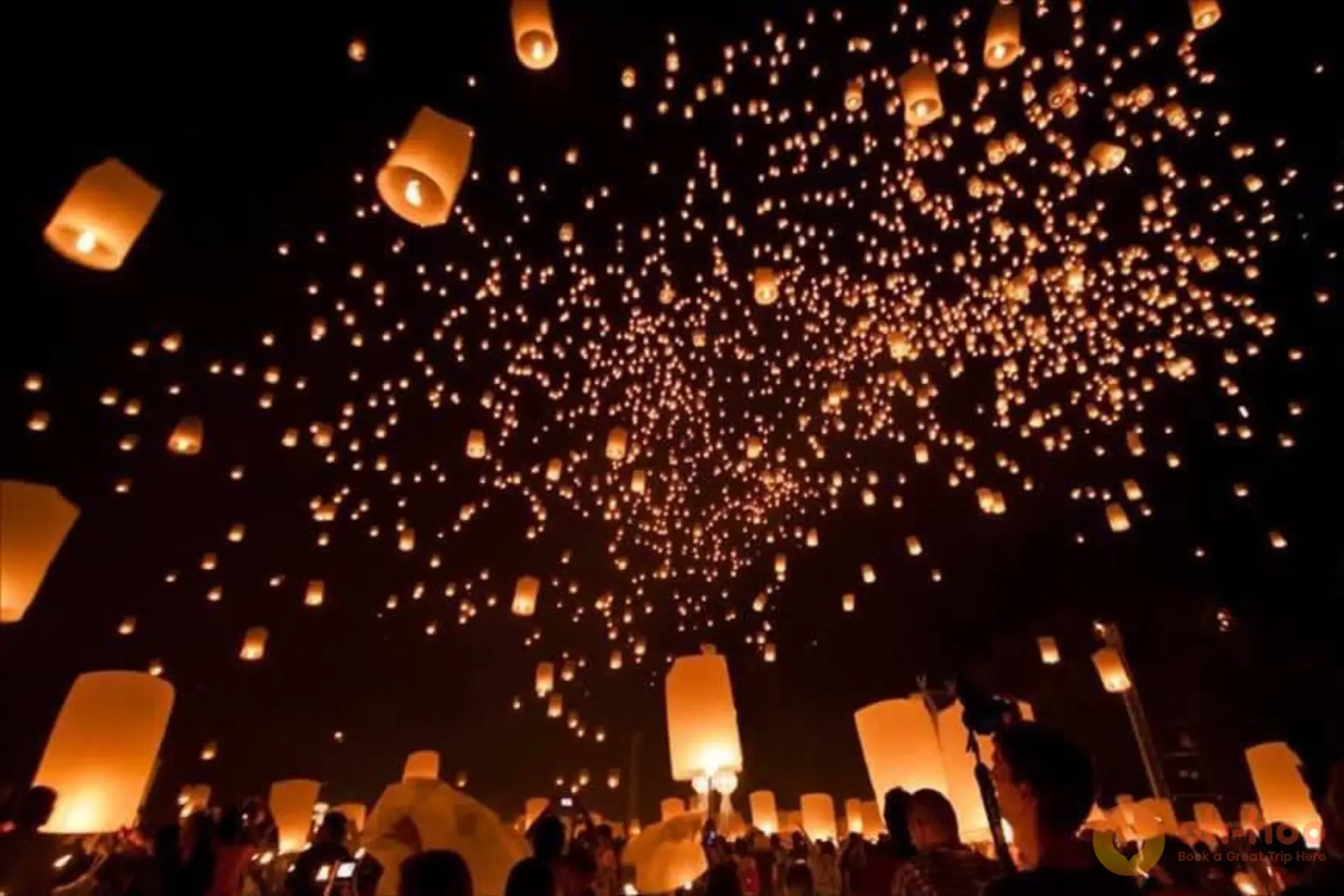 Thousands of sky lanterns rising into the night sky at the Yi Peng Lantern Festival in Chiang Mai
