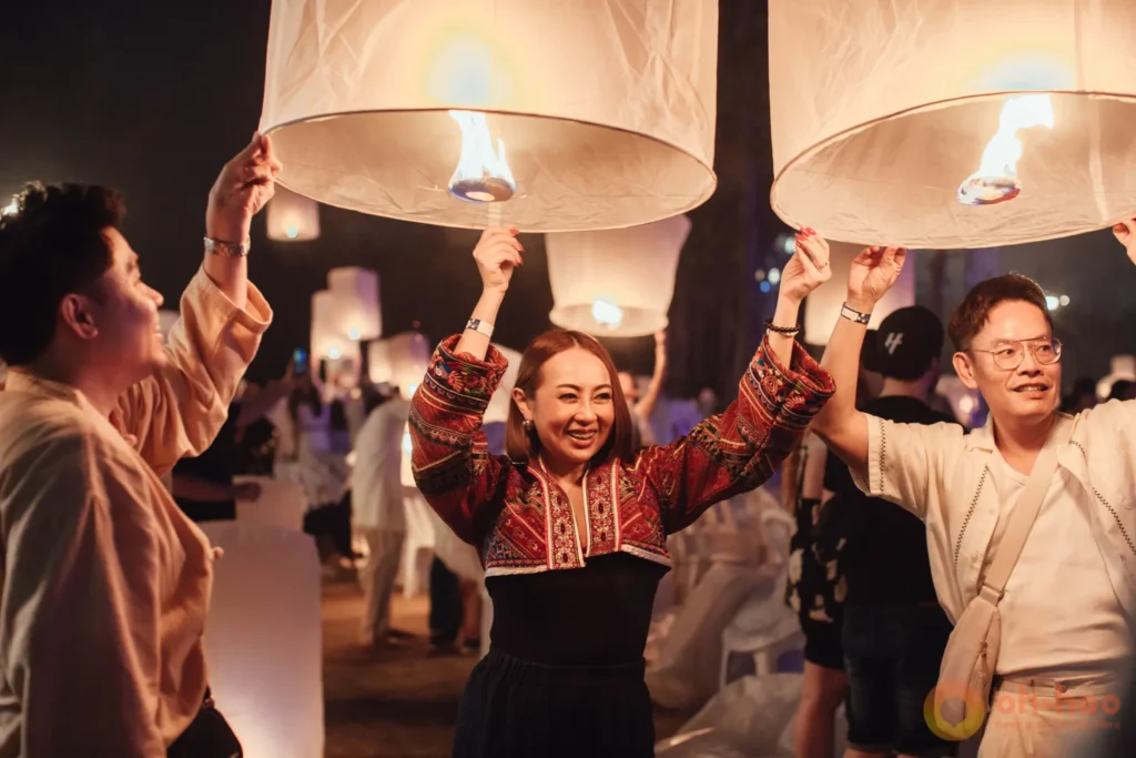 Visitors in traditional Lanna dress holding lanterns before the release at a Chiang Mai festival