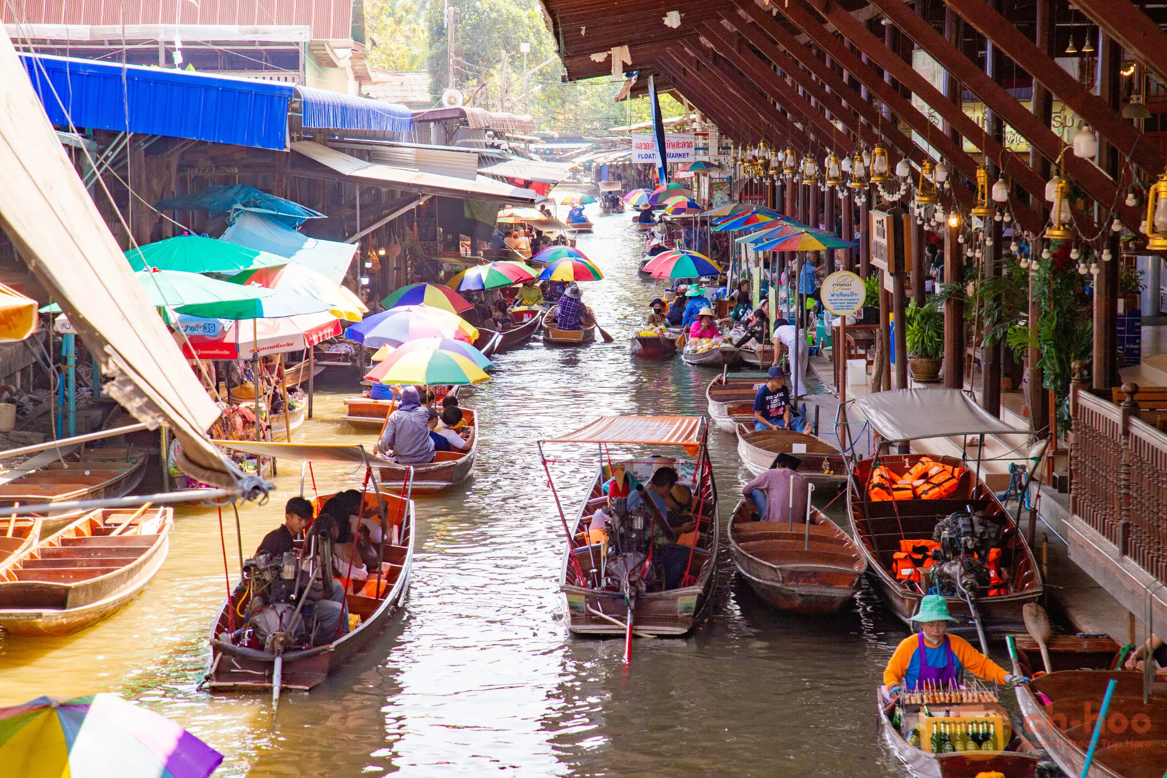 Long-tail boats and vendor boats loaded with fruit on the main canal at Damnoen Saduak Floating Market