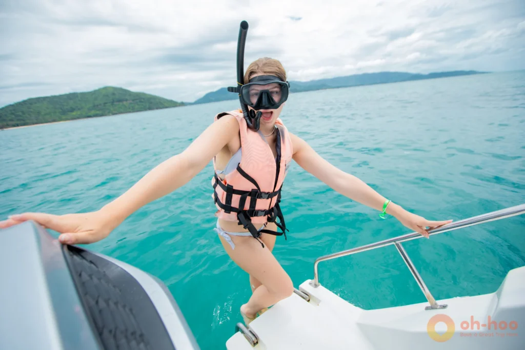 Passengers in life jackets took a photo on a tour speedboat crossing calm water near Koh Samui