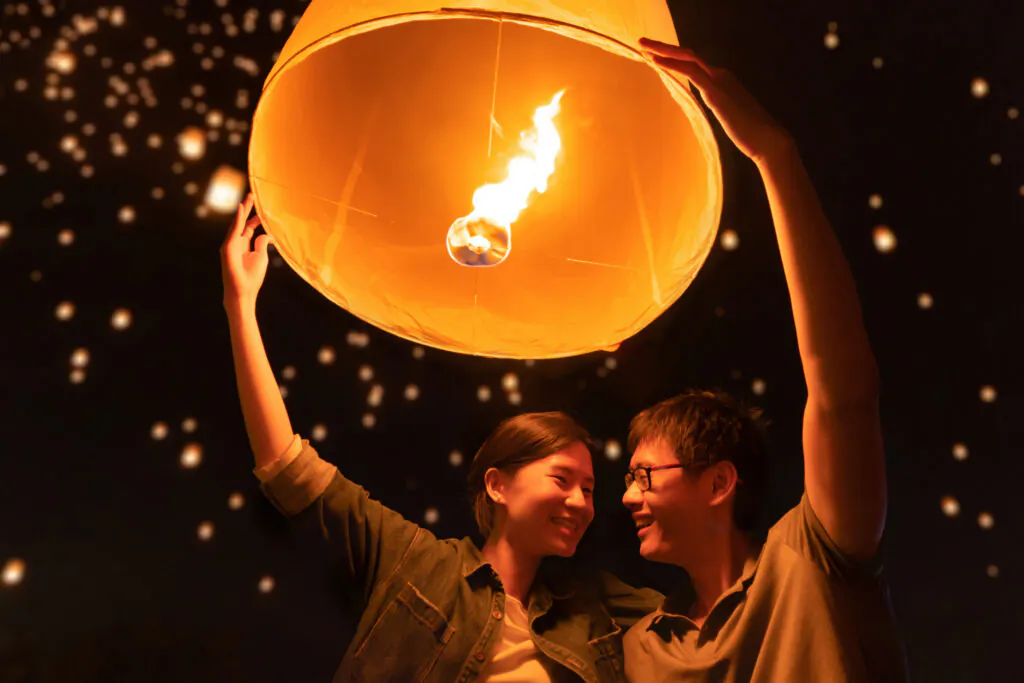 Visitors lighting a paper sky lantern together