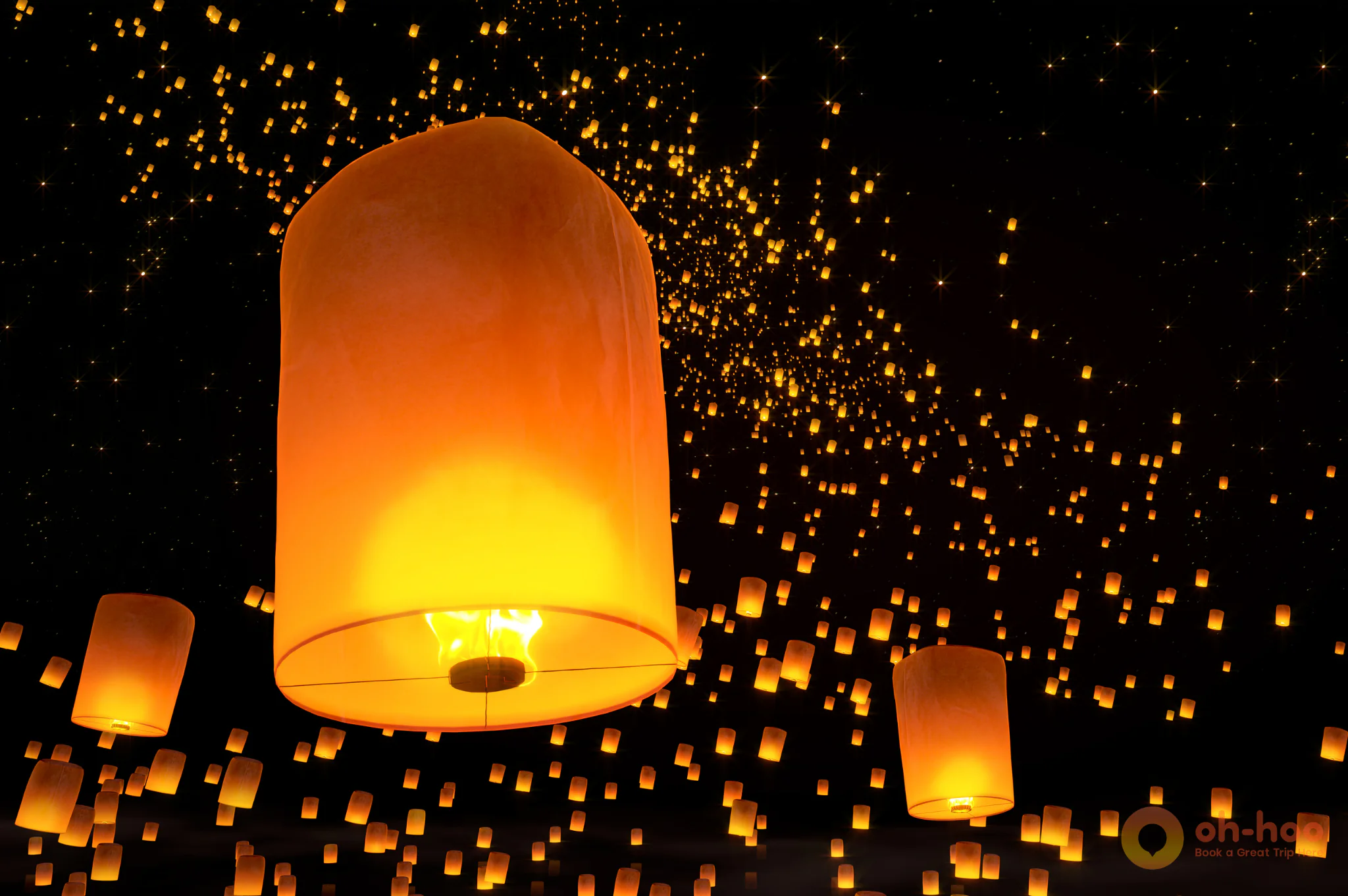 Thousands of sky lanterns rising into the night sky at the Yi Peng Lantern Festival in Chiang Mai