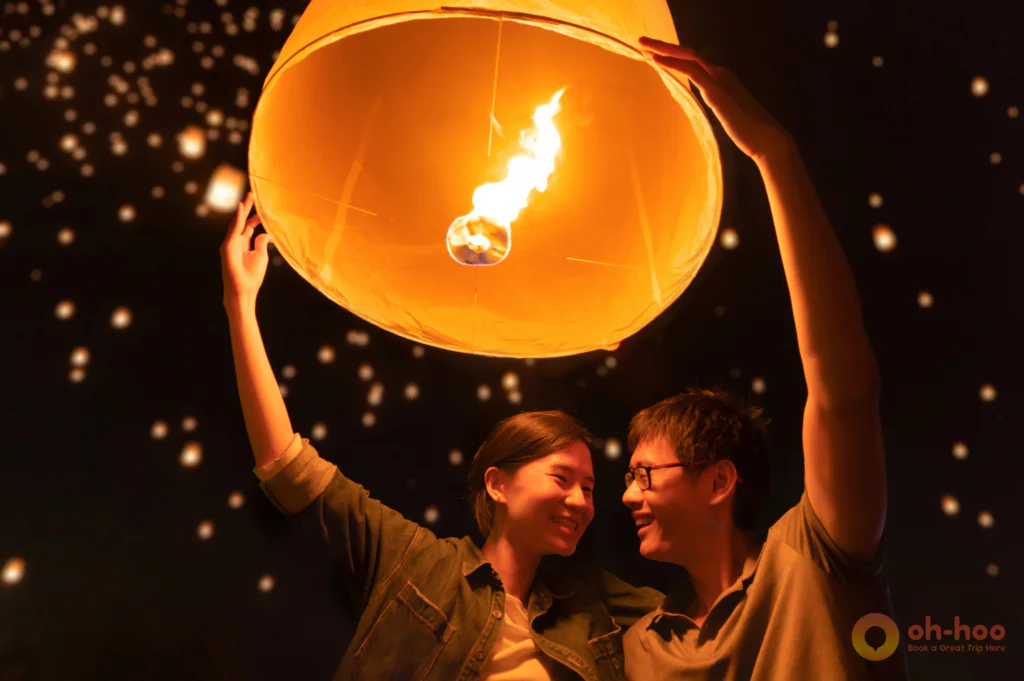 Visitors lighting a paper sky lantern together