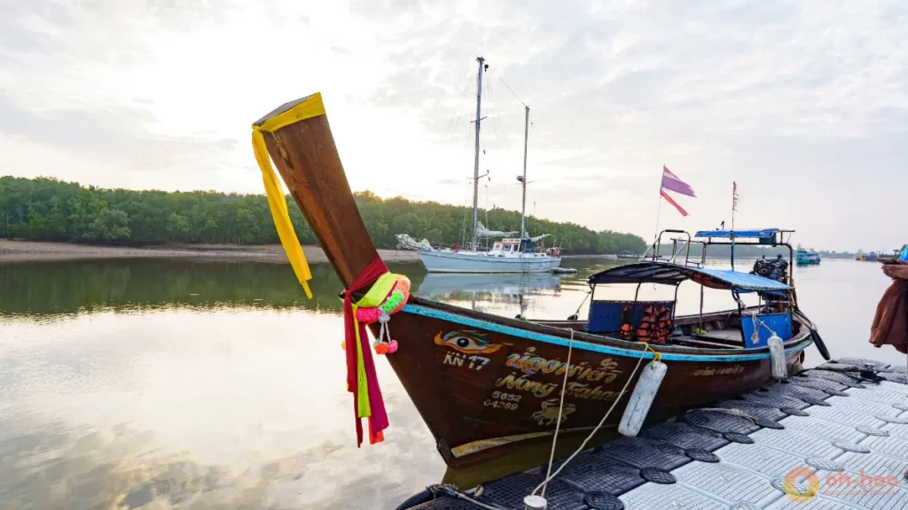Traditional longtail boat at a pier for the phuket to koh yao noi journey across calm coastal water.