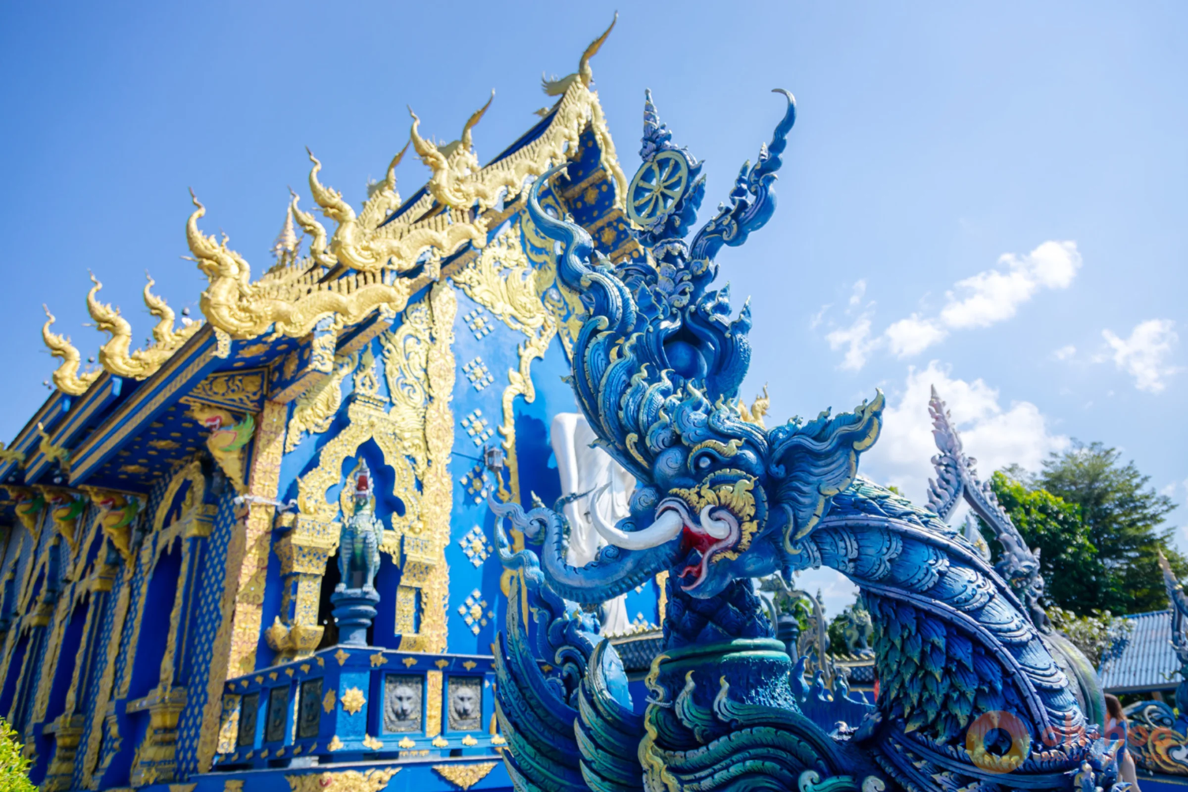 The sapphire blue and gold exterior of Wat Rong Suea Ten, the Blue Temple, in Chiang Rai