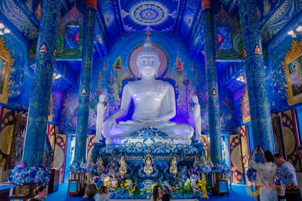 Interior of the Blue Temple showing the large white Buddha against deep blue walls and gold detail