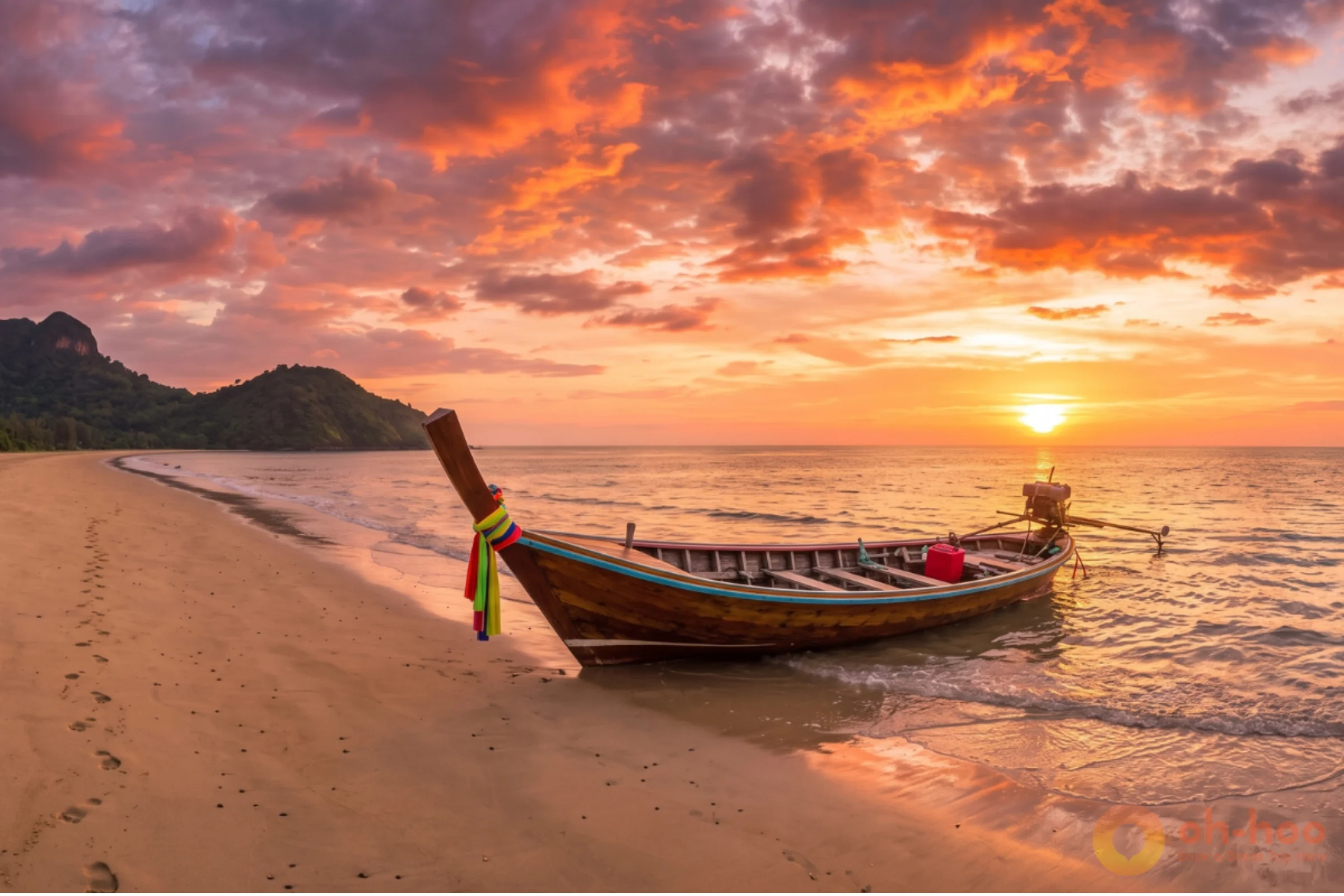 Long empty beach on Koh Lanta's west coast at sunset with a longtail boat on the sand