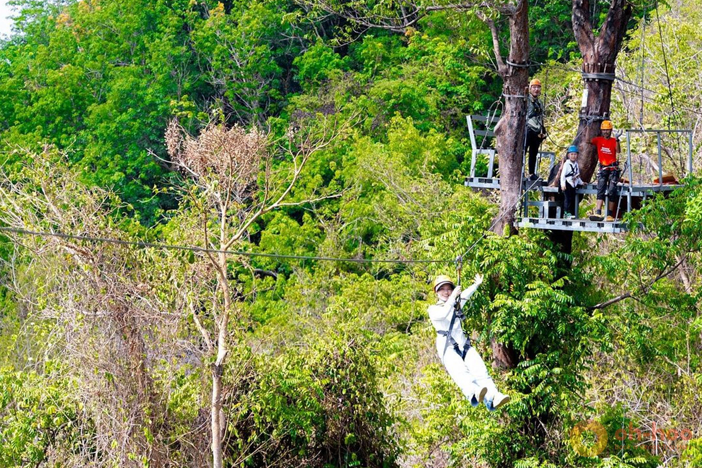 Rider gliding along a zipline high above the rainforest canopy in Phuket