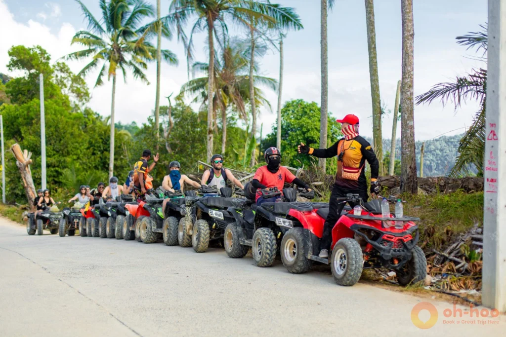 Line of quad bikes parked in Koh Samui with people on the seats