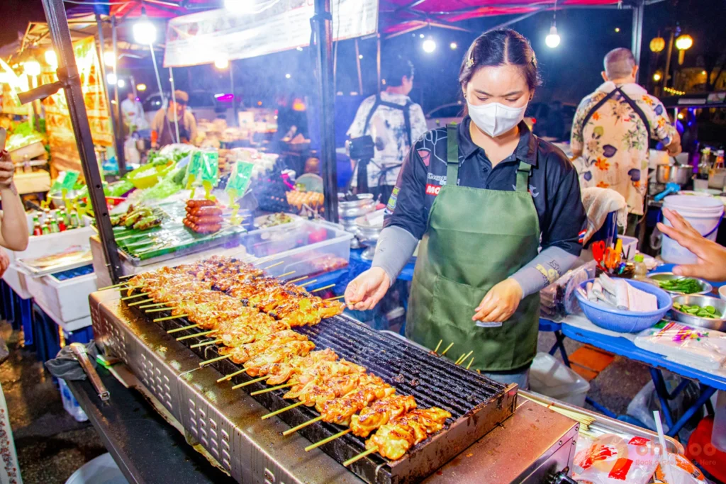 Night market food stalls lit up with crowds browsing in Chiang Mai