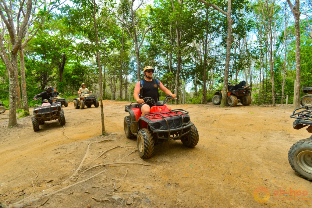Quad bikes on a jungle trail in Phuket with riders in helmets before the Big Buddha stop