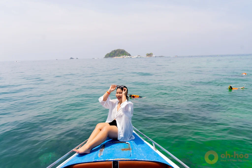 Longtail and speedboats moored off the white sand beach at Khai Nok island near Phuket