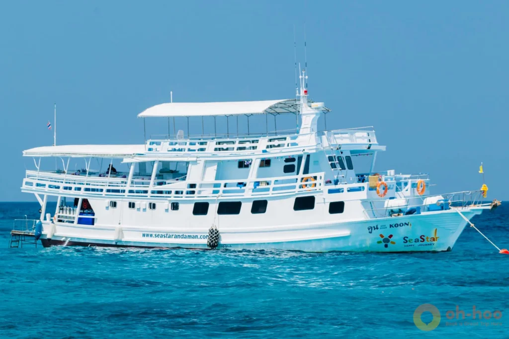 A liveaboard dive boat anchored in the turquoise waters of the Similan Islands, Thailand
