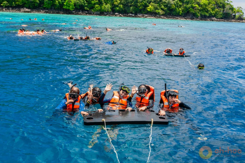Snorkellers in life jackets above a shallow reef at Mu Ko Surin National Park