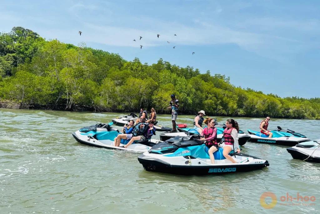Group of jet ski riders in life jackets following a guide between islands in Phang Nga Bay
