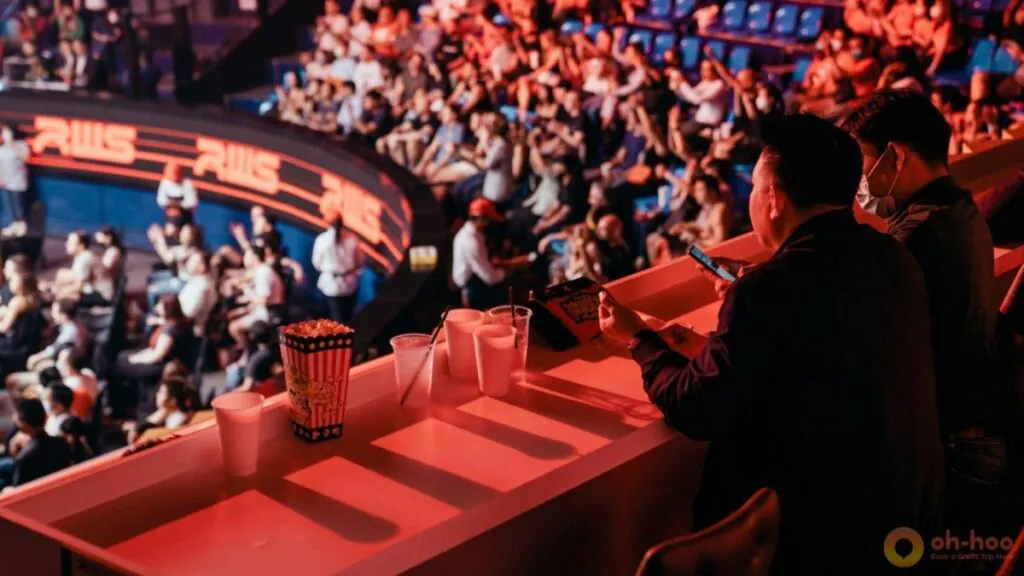 Guests in the Rajadamnern VIP Lounge watch from an elevated counter overlooking the arena, with drinks and snacks placed on the counter.