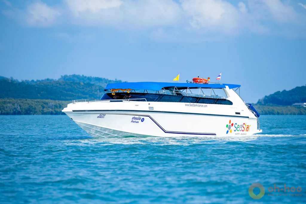 Speedboat entering the emerald waters of Pileh Lagoon surrounded by vertical limestone cliffs in Phi Phi Leh