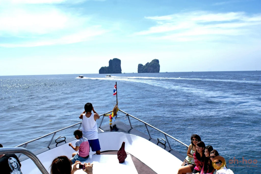 Passengers and families relaxing on the spacious open deck of a passenger ferry heading to Phi Phi Island